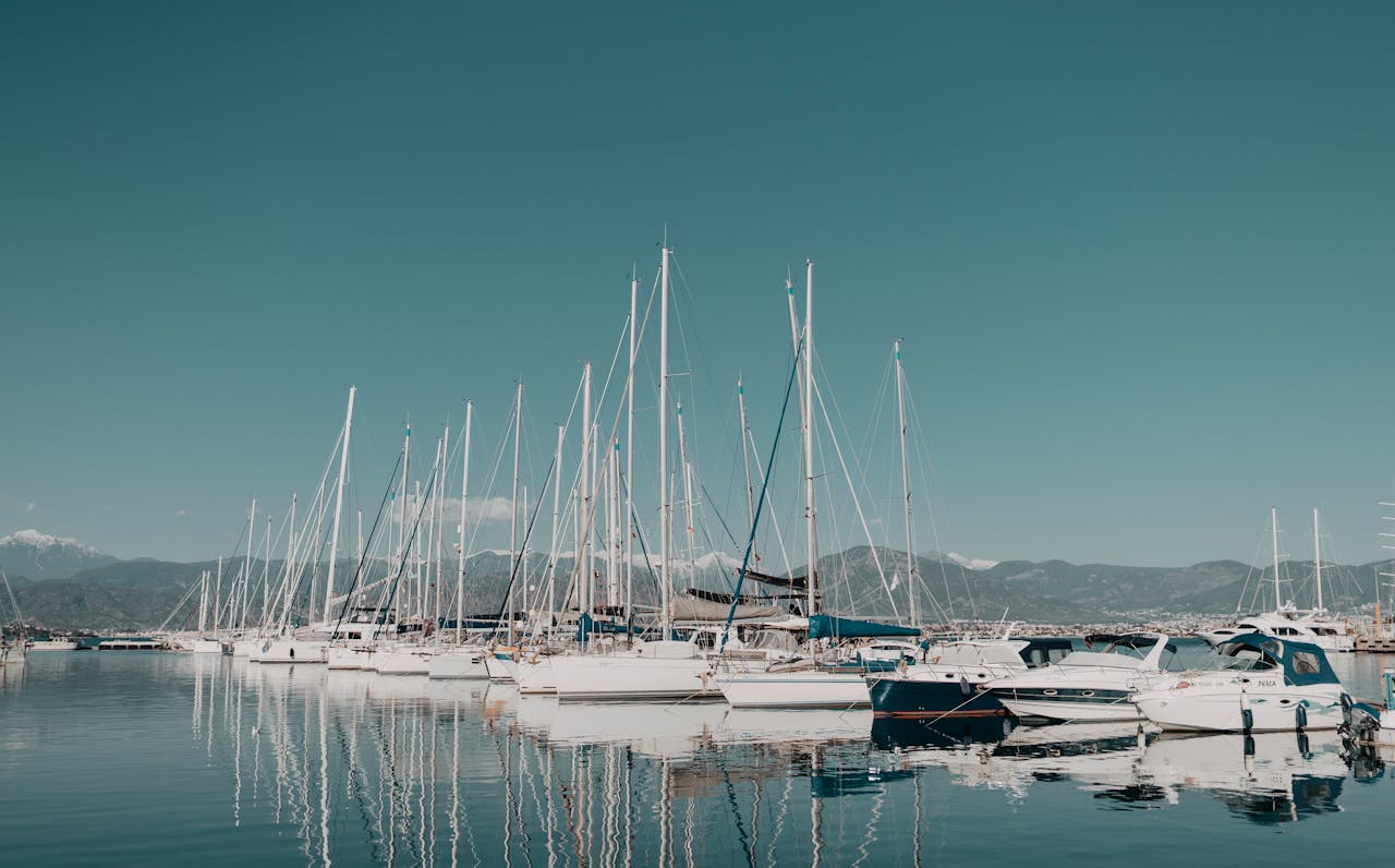 A serene view of sailboats docked at Fethiye marina on a bright summer day.